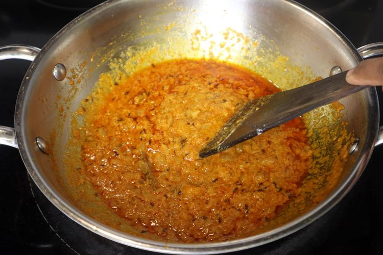Step 2.4: Lower the flame, add curd, and cook until the oil separates again