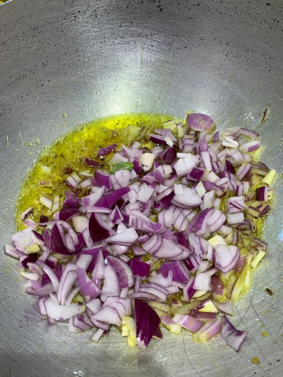 Step 1.1: Add the chopped onions to the wok and stir and cook them until they turn light golden