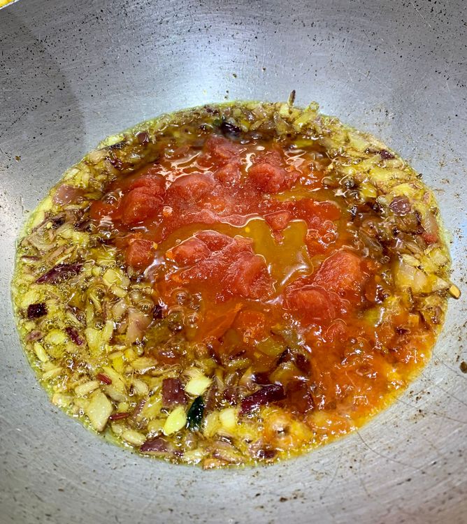 Step 1.1: Add the chopped tomatoes to the wok and cook them for 2-3 minutes until they become soft and mushy