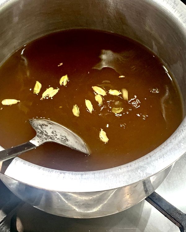 Step 1.2: Mix sugar, water, and green cardamoms in a deep pan