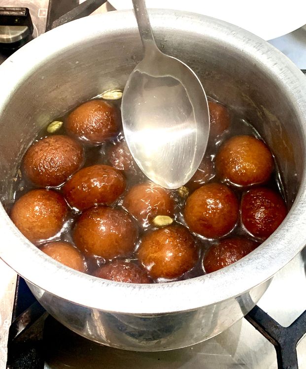 Step 2.1: Immediately put the fried balls into the hot sugar syrup and gently dip them with a spoon to coat them evenly