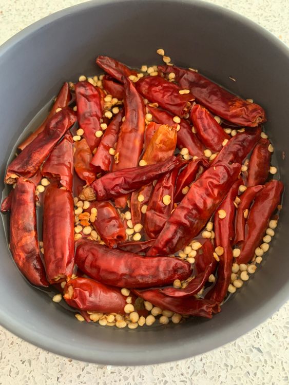 Step 1.1: Remove the stems from the dry red chillies and soak them in hot water for 15-20 minutes, or until they become soft and pliable