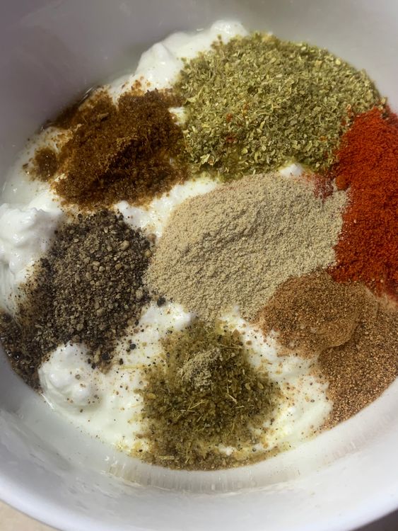 Step 2.1: In a mixing bowl, whisk together the yogurt, salt, coriander powder, cumin powder, black pepper,  green cardamom powder, carom seeds, cinnamon powder, red chilli powder,  white pepper and kashmiri red chilli powder