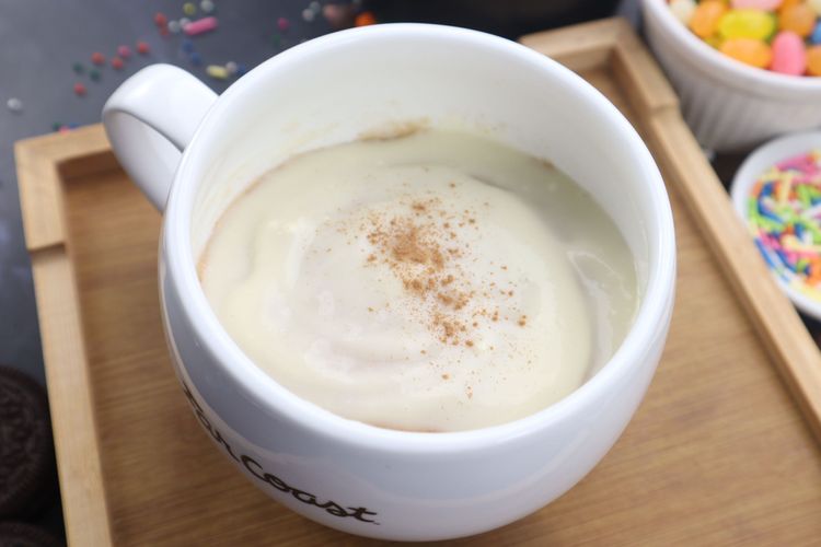 Step 3.1: Spread the cream cheese frosting over the warm mug cake