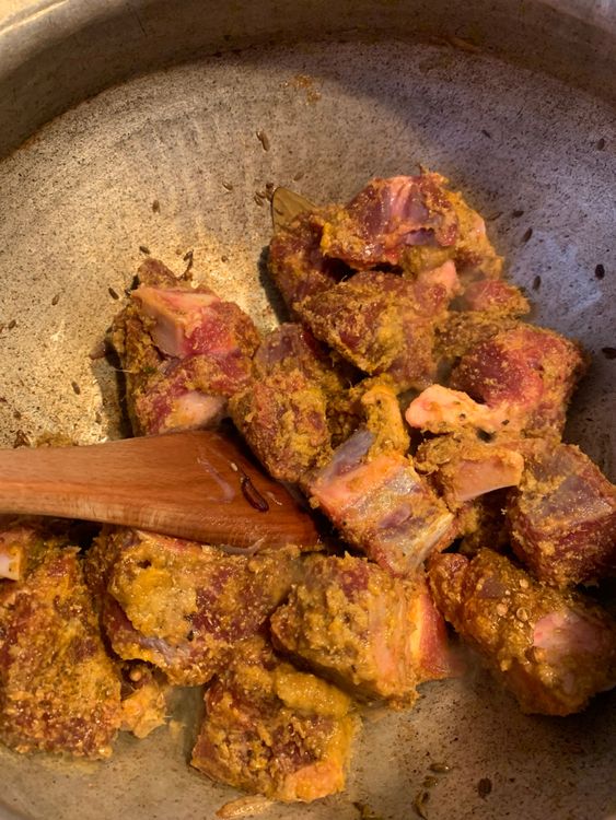 Step 3.1: Add the marinated mutton to the wok and cook, stirring continuously, until the mutton changes colour