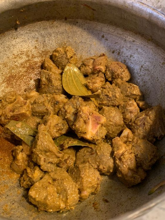 Step 3.2: Add the marinated mutton to the wok and cook, stirring continuously, until the mutton changes colour