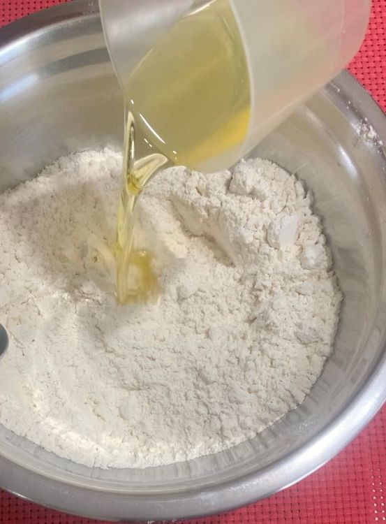 Step 1.1: Make a well in the centre of the flour mixture and pour in the yeast mixture and olive oil (5 tbsp)