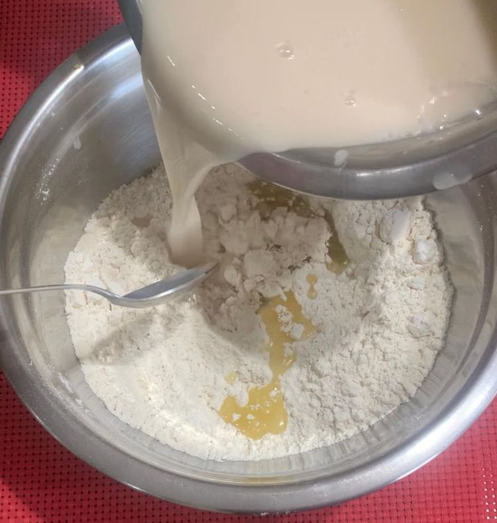Step 1.2: Make a well in the centre of the flour mixture and pour in the yeast mixture and olive oil (5 tbsp)