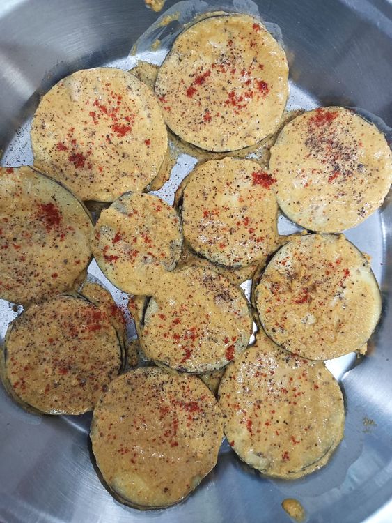 Step 1.1: Now in a plate put besan and coat each slice of the eggplant separately and place it on the tawa for frying