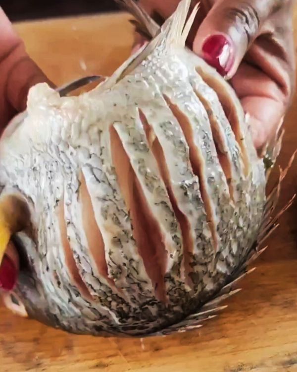 Step 2.1: Use a sharp knife to make multiple slits along both sides of the fish, about 1 inch apart