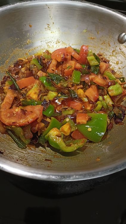 Step 3.1: Add chopped capsicum and tomato pieces to the pan