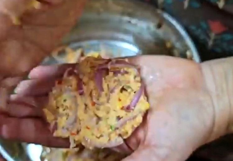 Step 1.2: When the oil becomes hot, take a small ball of the mixture, gently press it with your hands to make a vada shape, and drop it into the hot oil