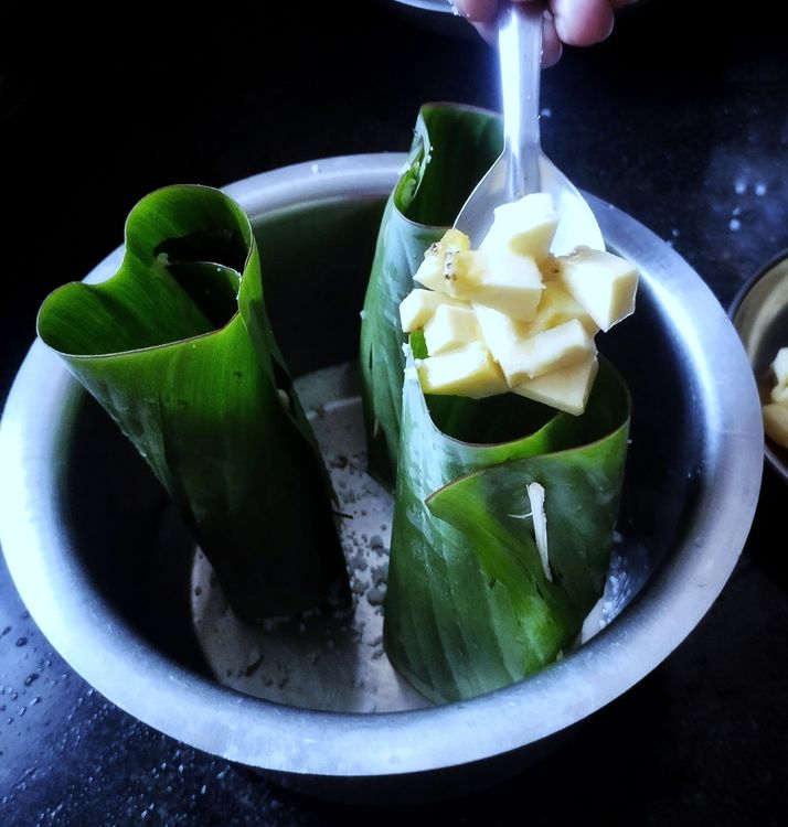 Step 1.1: Add some banana pieces, then layer it with rice flour mixture