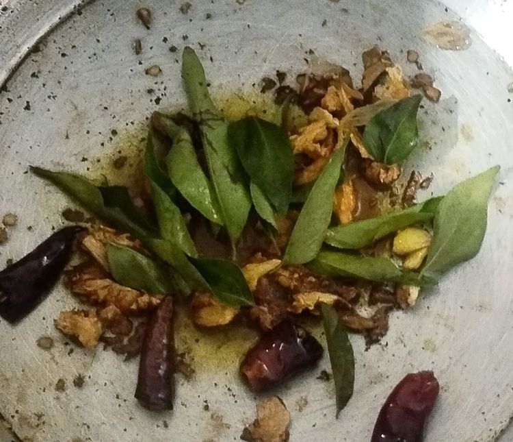 Step 1.1: Turn the flame to low and add curry leaves, turmeric powder, and salt