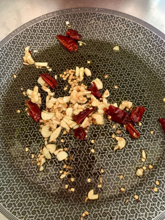 Step 1.1: Add the chopped garlic and broken dry red chillies to the skillet