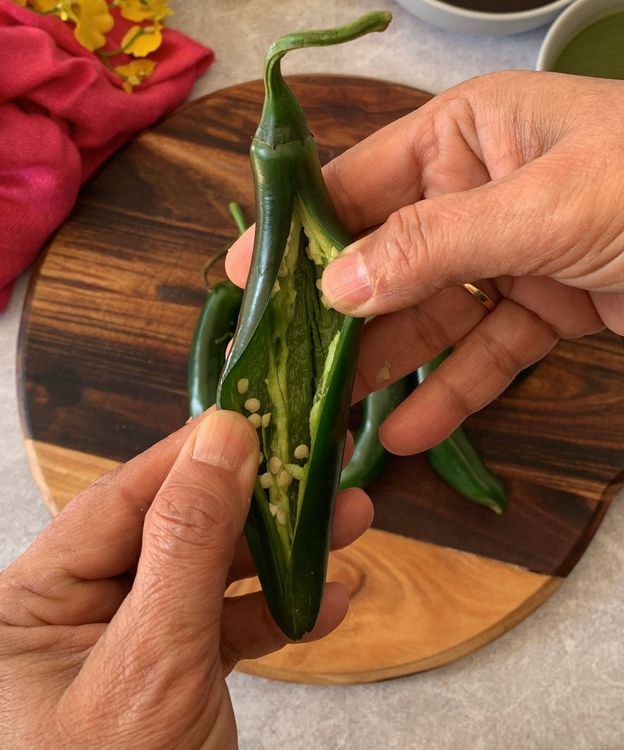Step 1.1: Slit the green chilli peppers lengthwise, keeping the stem intact