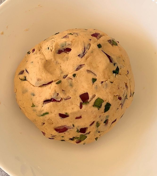 Step 1.1: Add water gradually to the bowl and mix well to form a thick, smooth dough