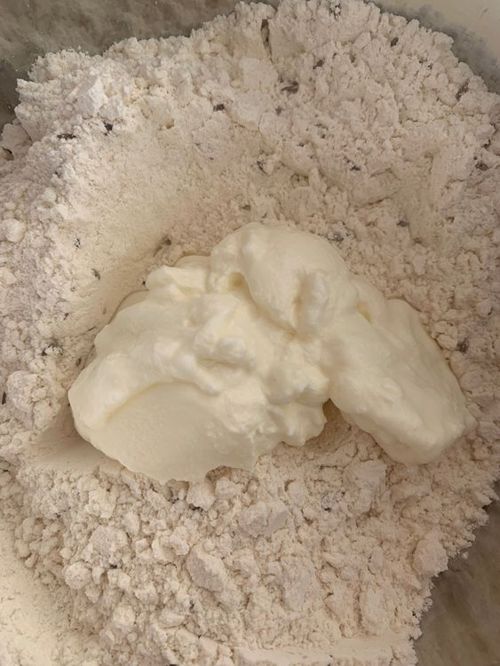 Step 1.1: Add curd and gradually add water to form a thick batter (drop consistency)