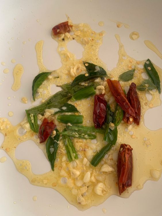 Step 5.1: Add the green chilies, dry red chilies, and curry leaves
