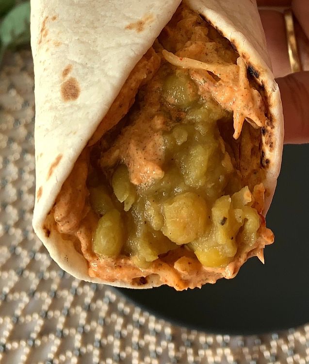 Step 3.2: Place a spoonful of warm mashed peas over the chutney in the centre of the wrap and roll it up
