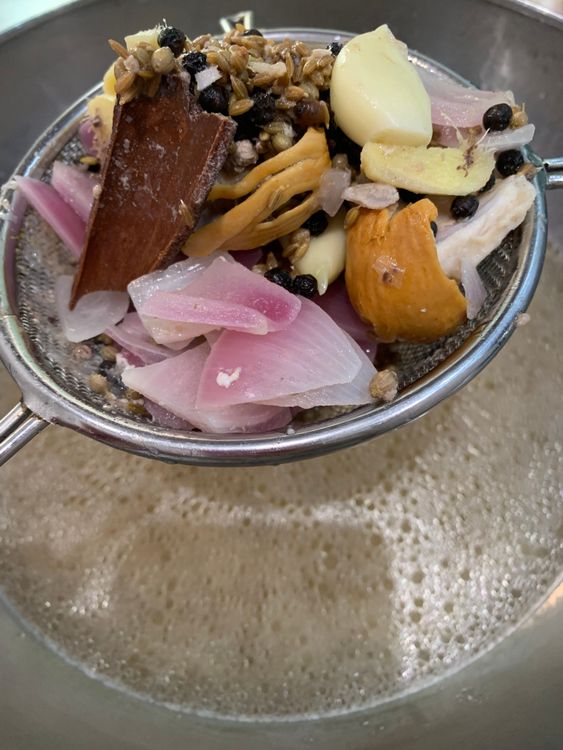 Step 2.1: Strain the broth (yakhni) into a bowl to remove the whole spices, reserving the broth for later use