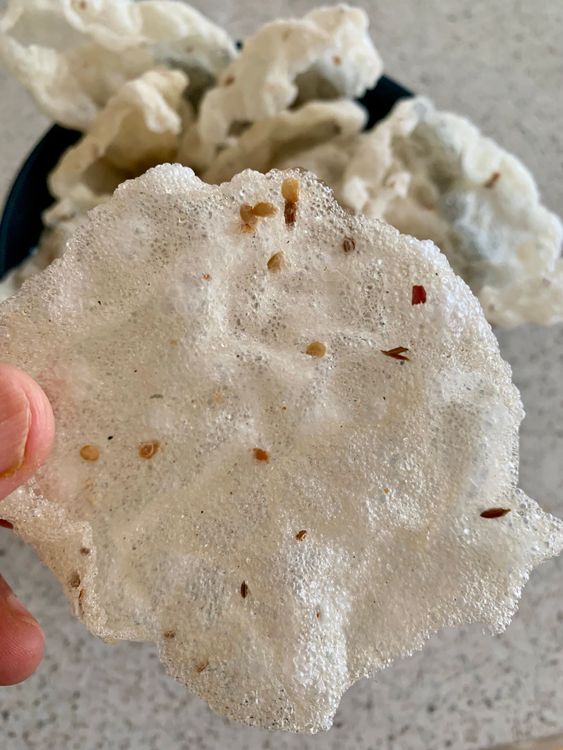 Step 3.1: Gently slide a papad into the hot oil and press it lightly with a slotted ladle to puff it up