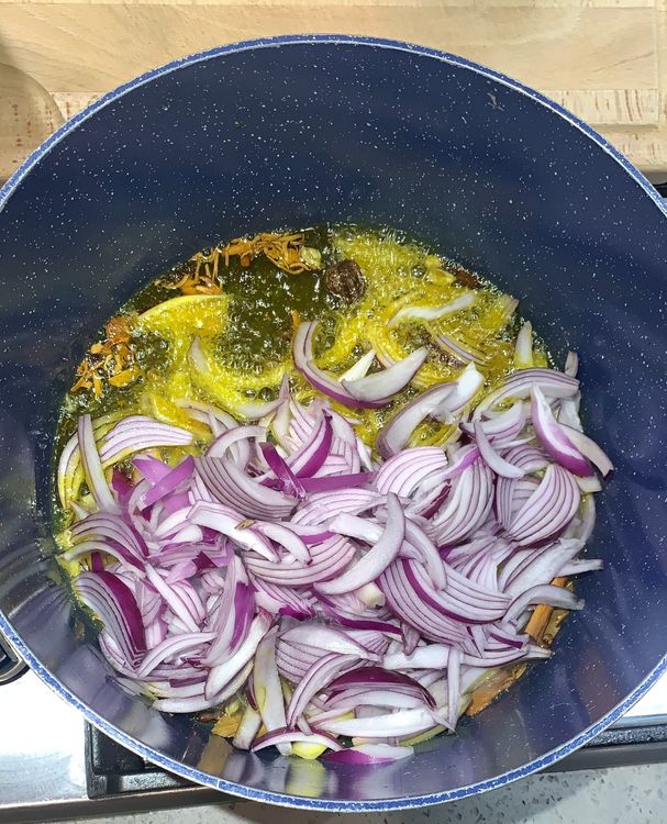 Step 1.1: Add the sliced onions to the wok and saute until they turn translucent and pinkish in colour