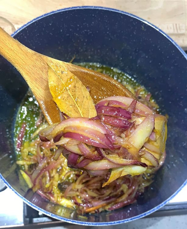 Step 1.2: Add the sliced onions to the wok and saute until they turn translucent and pinkish in colour