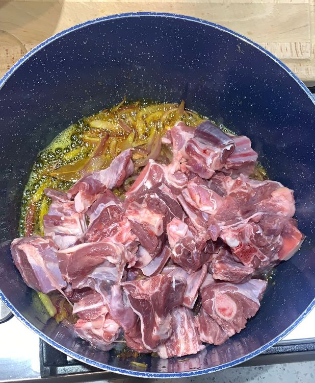 Step 1.1: Add the mutton pieces to the wok and let them cook over medium-high heat for a few minutes, stirring occasionally, until they change colour and the oil starts leaving the sides