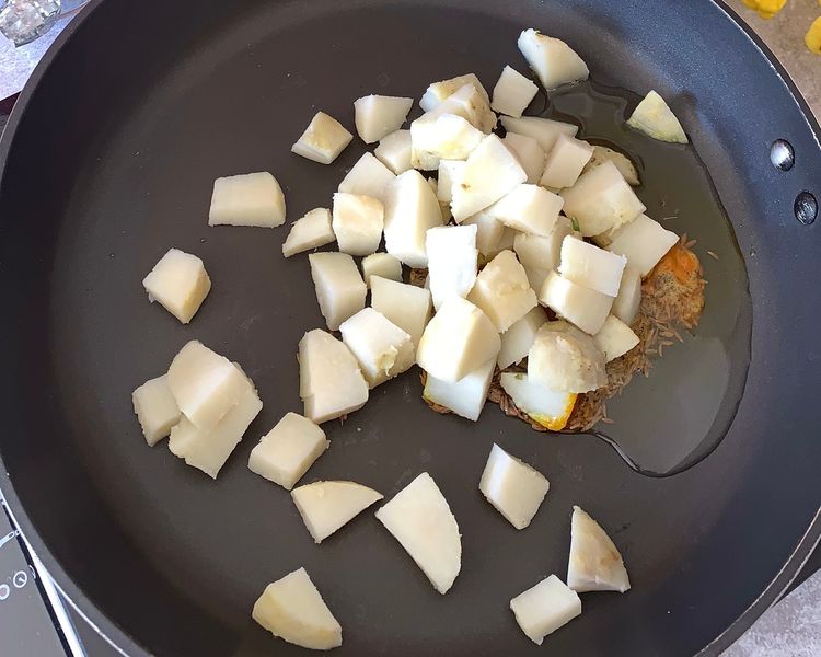 Step 1.1: Add turmeric and boiled potatoes into the pan and toss them well