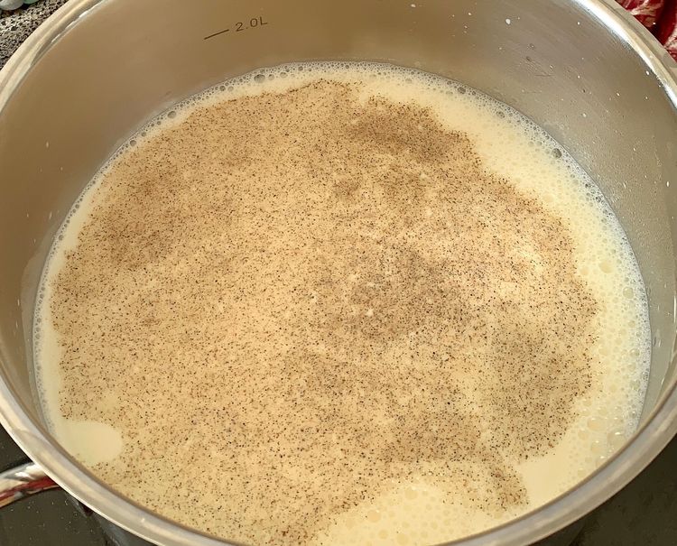 Step 1.1: In the same pan, pour in the milk and add the cardamom powder