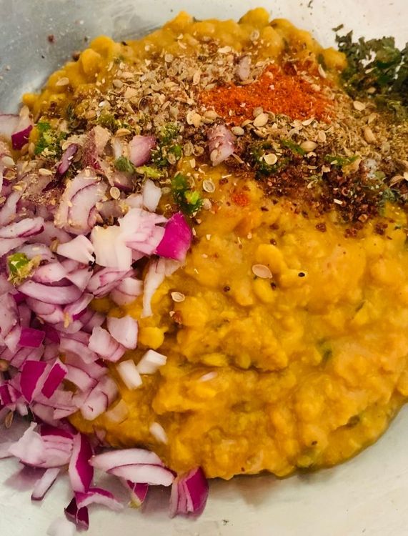 Step 1.1: In a large mixing bowl, combine the cooked lentils (daal), wheat flour, chopped onions, green chillies, salt, red chilli powder, coriander powder, dry pomegranate seed (anardana), dry fenugreek leaves and garam masala