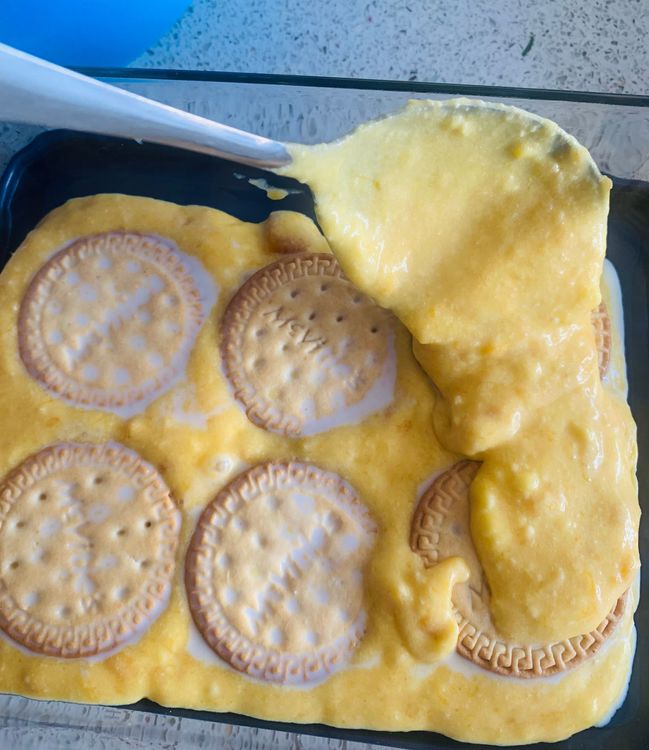 Step 3.2: Repeat the process, alternating layers of biscuits and mango cream