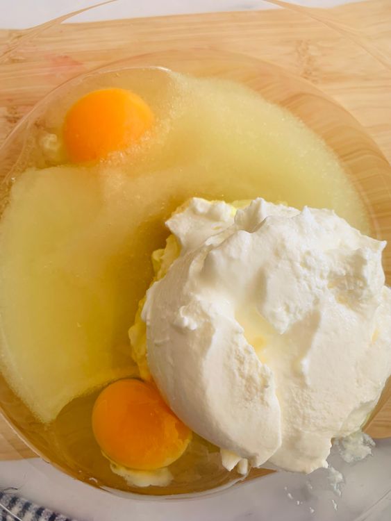 Step 4.1: In a large mixing bowl, crack the eggs and add the sugar, vanilla essence, lemon juice, oil, and yogurt