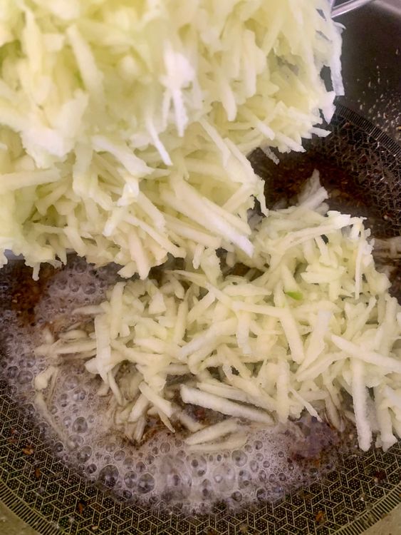 Step 2.1: Drain the grated apples and add them to the wok