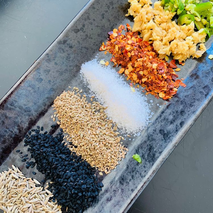 Step 1.1: In a pan, bring water, nigella seeds, cumin seeds, carom seeds, chilli flakes, salt, chopped ginger, and green chillies to a boil
