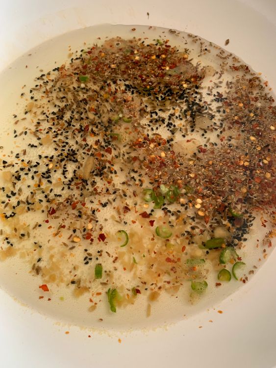 Step 1.2: In a pan, bring water, nigella seeds, cumin seeds, carom seeds, chilli flakes, salt, chopped ginger, and green chillies to a boil