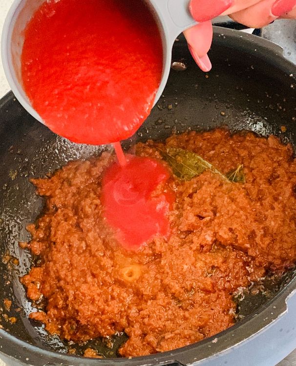 Step 2.1: Add tomato puree, dry fenugreek leaves, turmeric, salt, and coriander powder to the wok and stir to combine