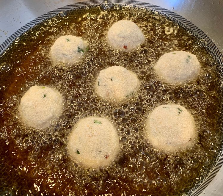 Step 1.1: Carefully place the coated chicken balls in the hot oil and fry them until they turn slightly golden