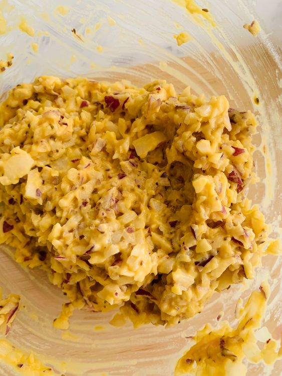Step 2.1: In a mixing bowl, combine chopped onions, potatoes, gram flour, carom seeds, and salt