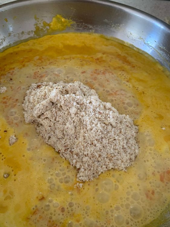 Step 1.1: Stir in the ground nut-coconut blend and continue cooking until the mixture thickens and comes together like soft dough