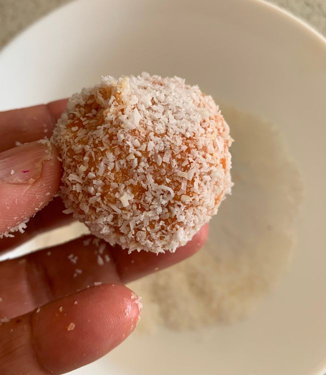 Step 1.1: Roll each ladoo in the remaining desiccated coconut for an even coating