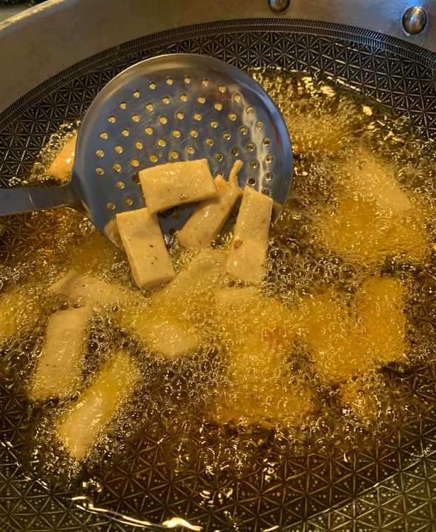 Step 1.1: Carefully slide a few suji bites at a time into the hot oil, stirring continuously ensuring even frying