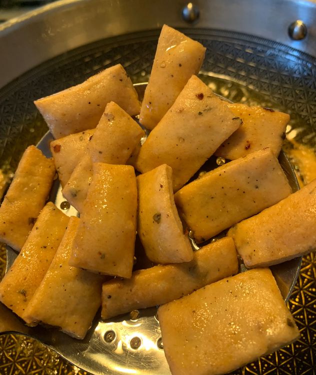 Step 1.2: Carefully slide a few suji bites at a time into the hot oil, stirring continuously ensuring even frying