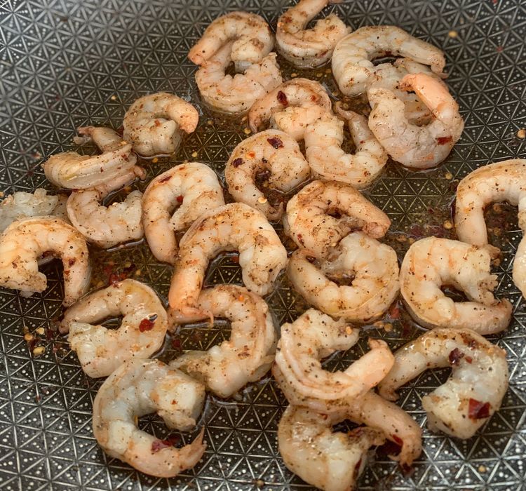 Step 1.2: Add red chilli flakes, black pepper powder, salt, and the prawns to the hot skillet