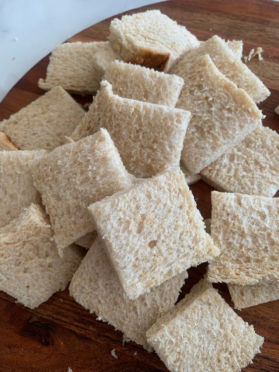 Step 1.2: Trim the edges of the bread slices and cut each slice into 4 small squares