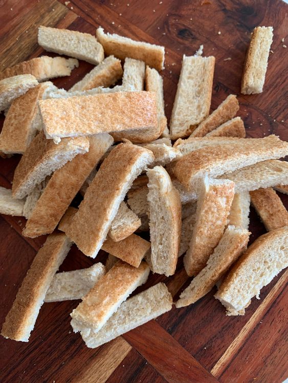 Step 1.1: Cut each bread slice into finger-length strips, then halve them into bite-sized pieces