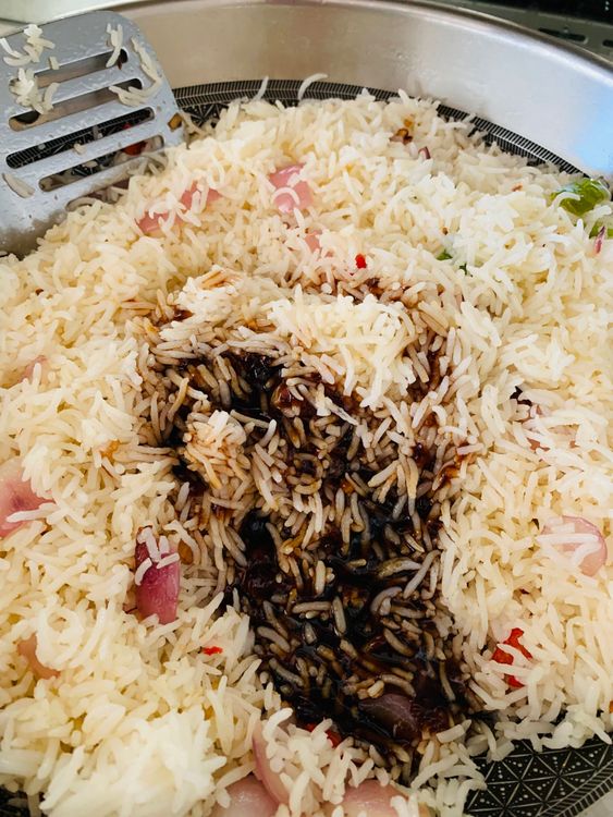Step 3.1: Pour the prepared sauce over the rice, ensuring it coats everything evenly