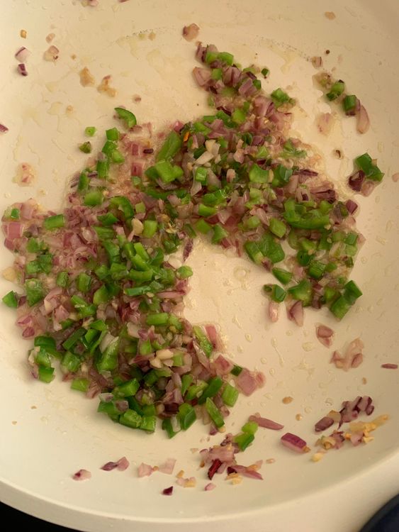 Step 4.1: Stir in capsicum and green chillies, stir-frying for 1-2 minutes until slightly softened but still crisp