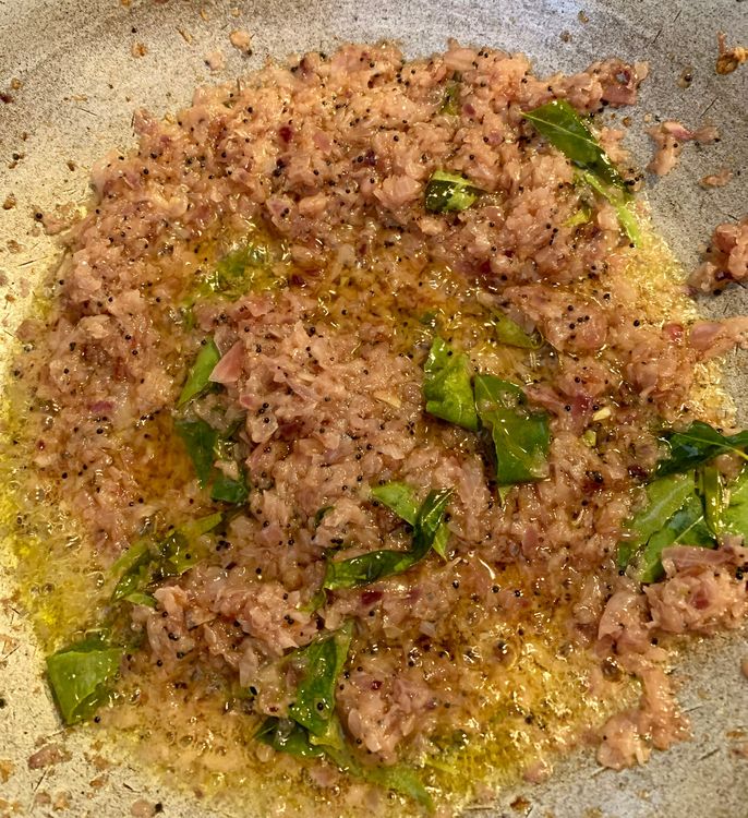 Step 1.2: Add the finely chopped onions and curry leaves, sauteing until the onions turn a golden brown colour
